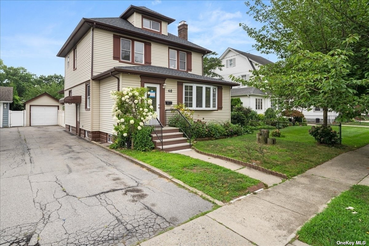 a front view of a house with a yard and potted plants