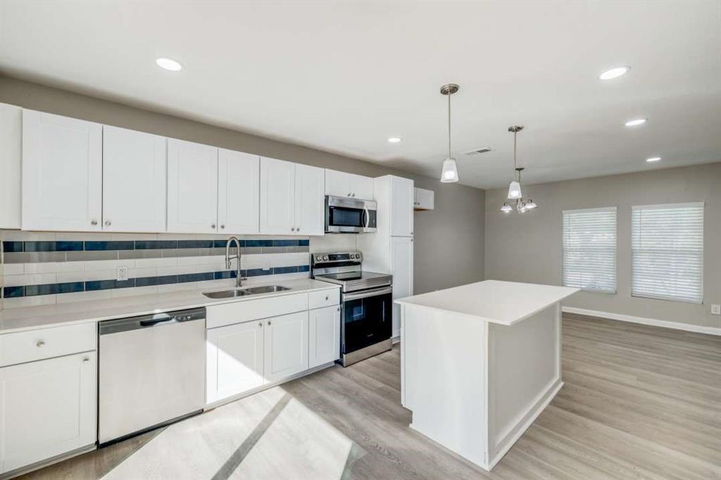 a kitchen with white cabinets and white appliances