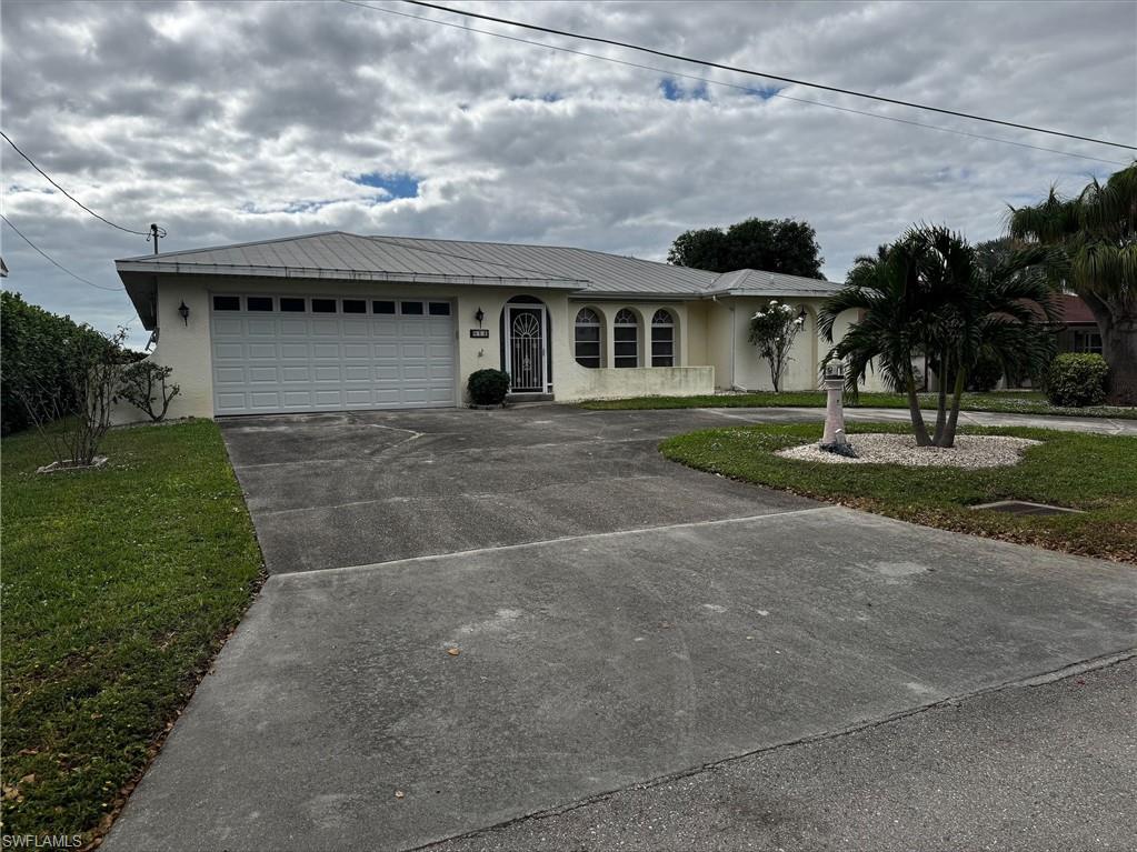 Ranch-style home with a front lawn and a garage