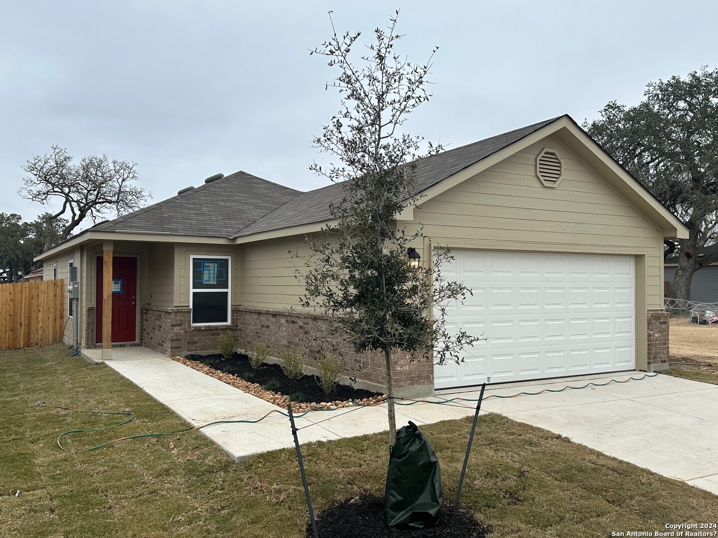 a front view of house with yard and trees in the background