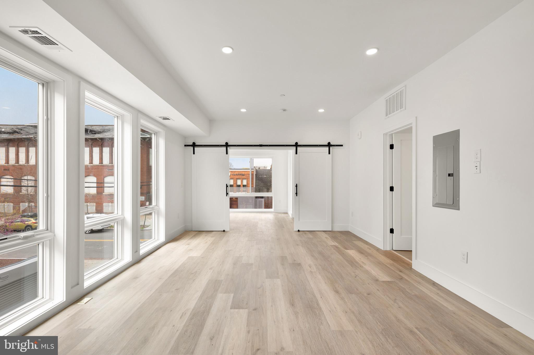 a view of an empty room with wooden floor