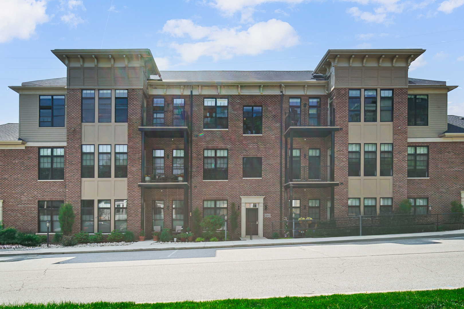 a front view of a residential apartment building with a yard