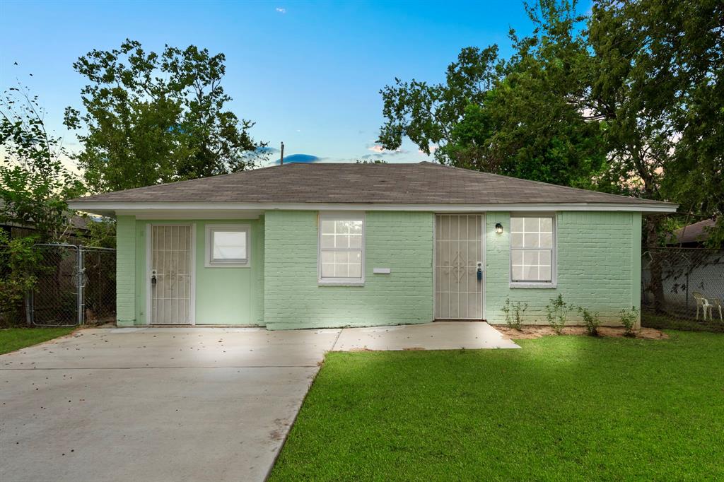 a front view of a house with a garden and yard