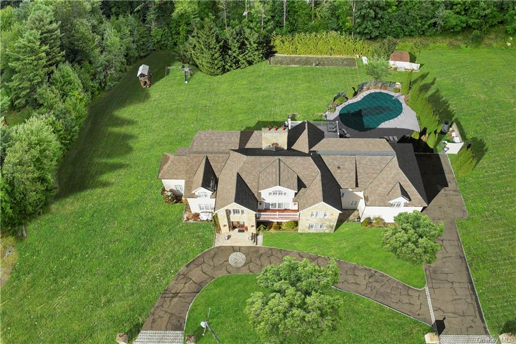 an aerial view of a house with garden space and a patio