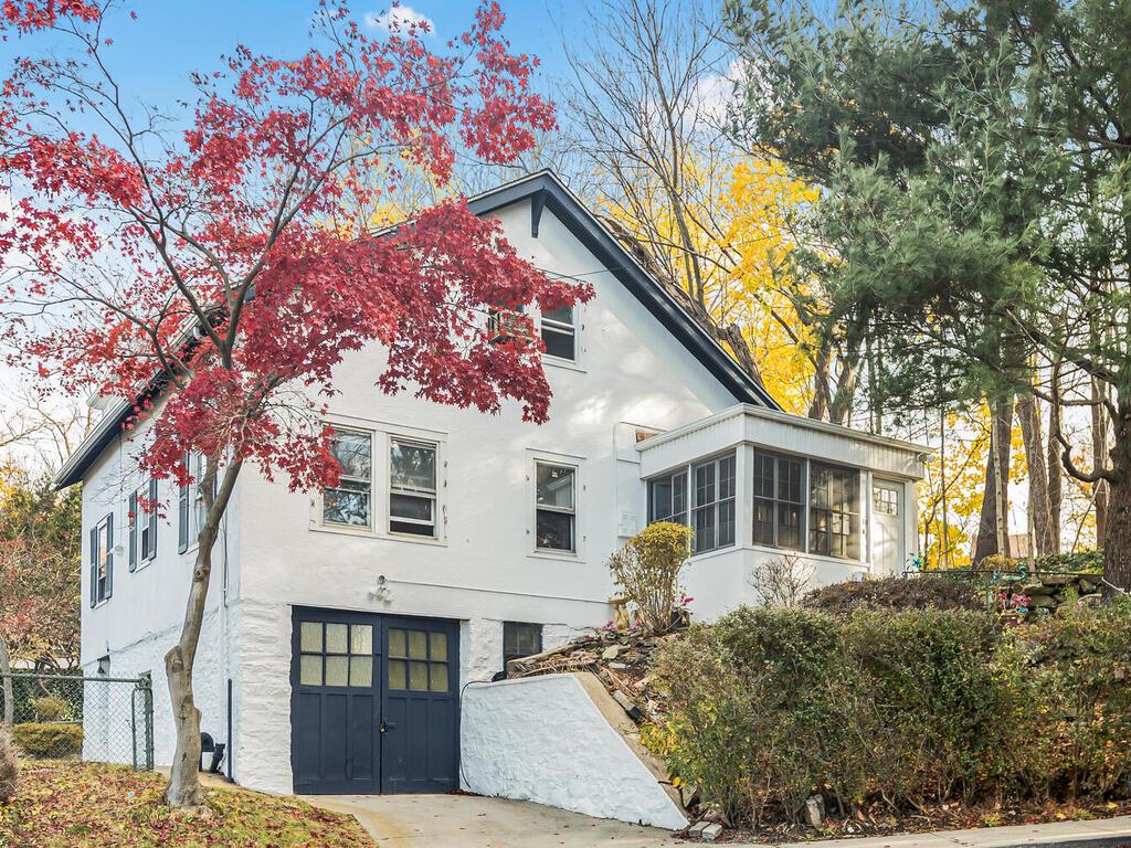 a front view of a house with a tree