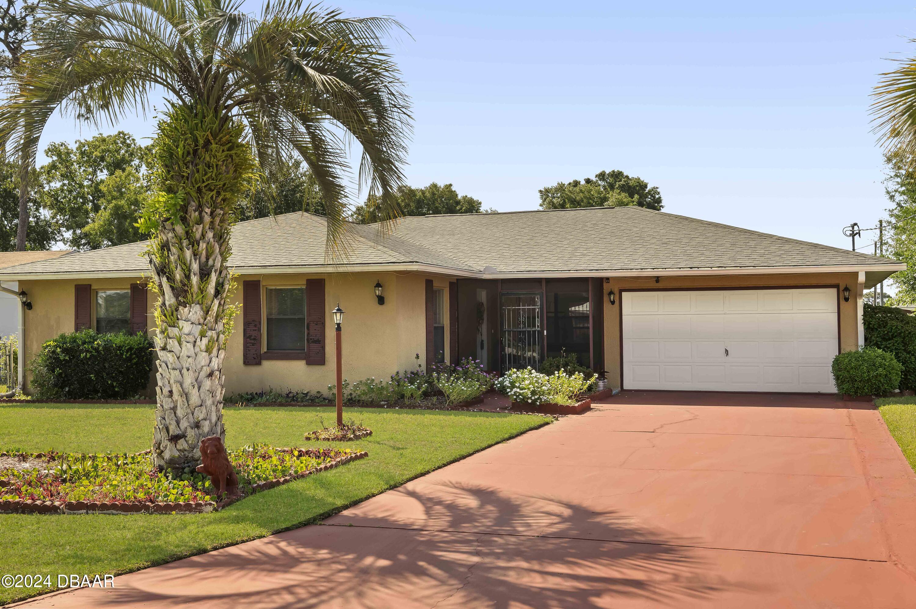 a front view of a house with a garden and yard