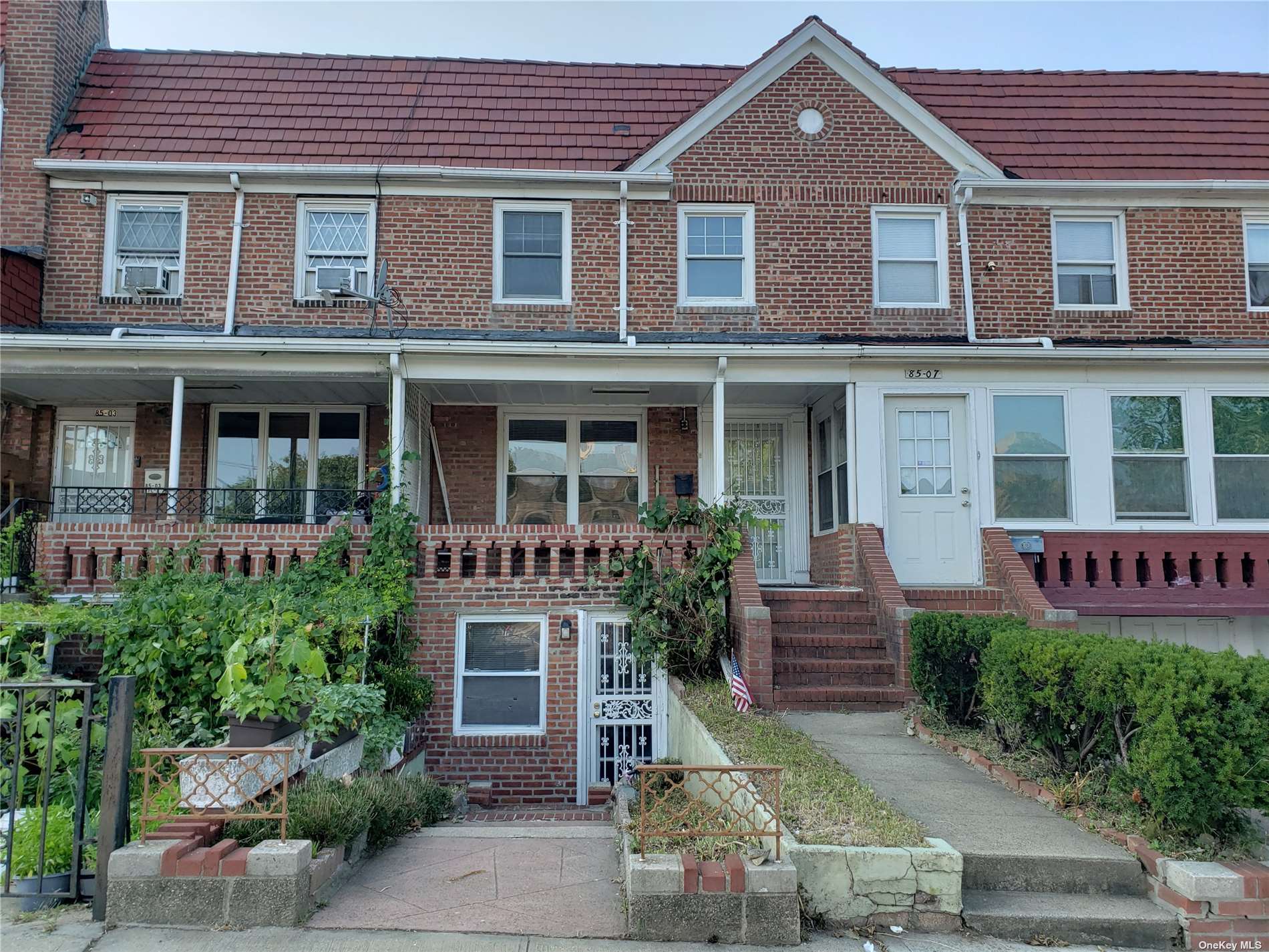 front view of a brick house with a large windows and a yard