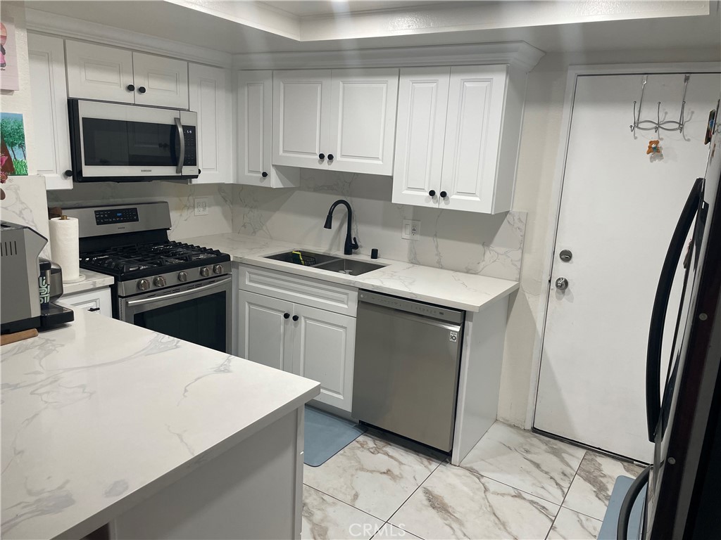 a kitchen with a sink stove and microwave