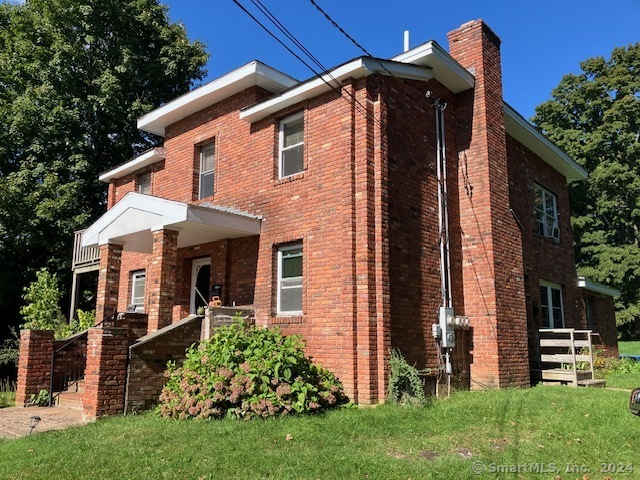 a front view of house with a garden