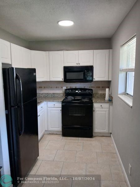 a kitchen with a refrigerator stove and microwave