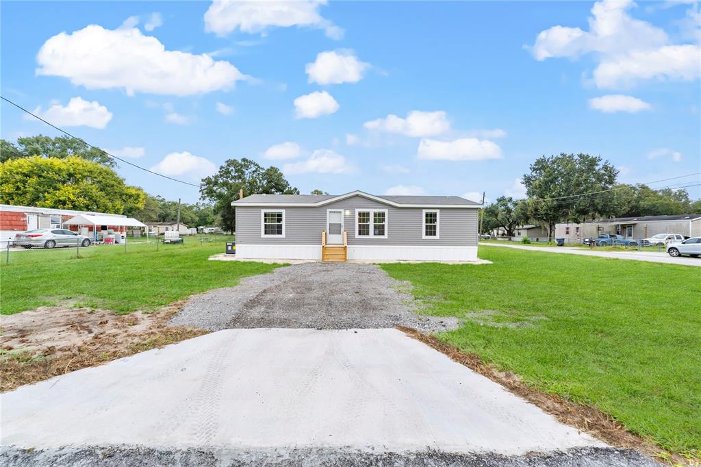 a front view of a house with yard and green space