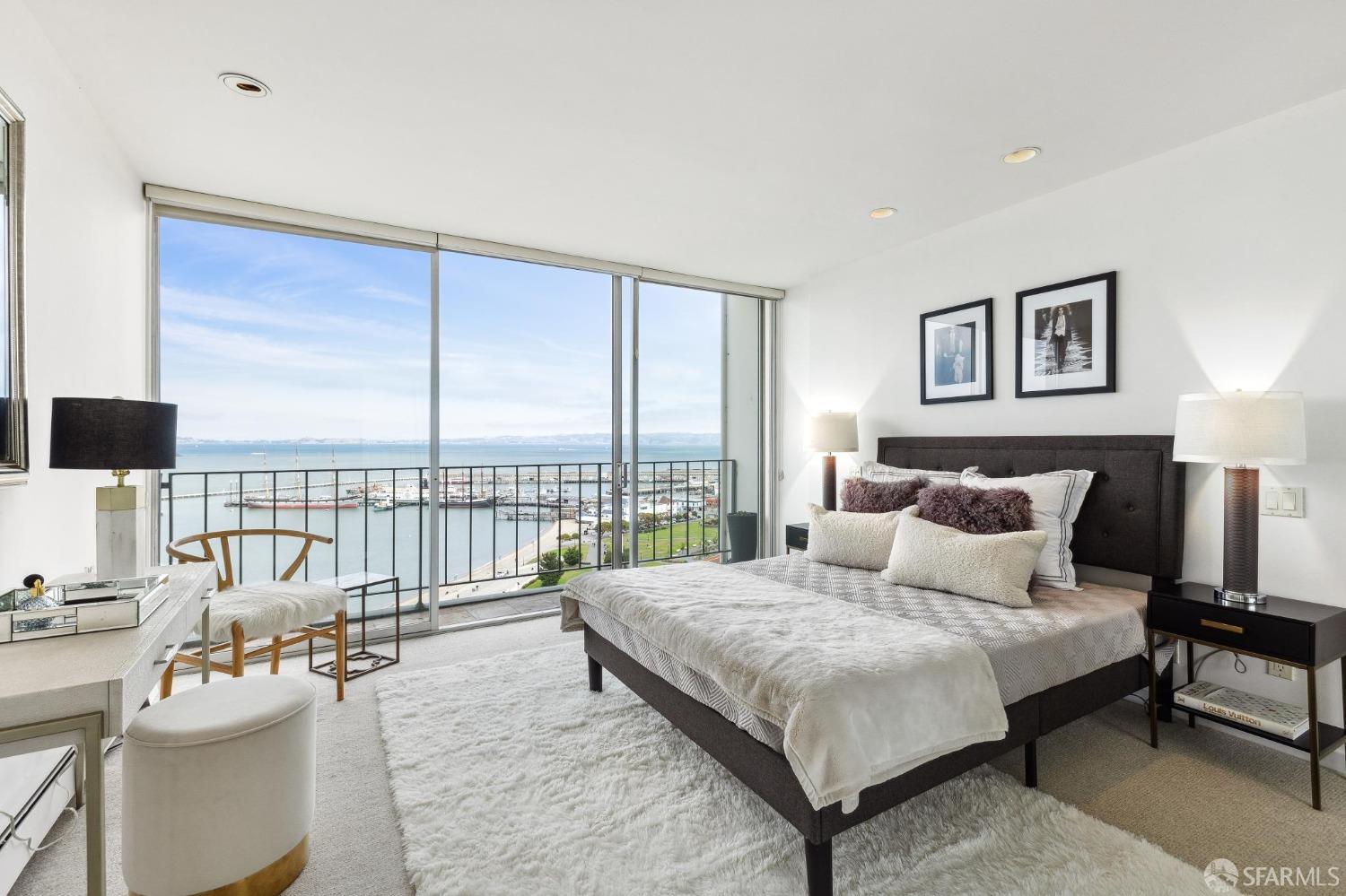 The primary bedroom has stunning views seen through floor-to-ceiling sliding glass door.