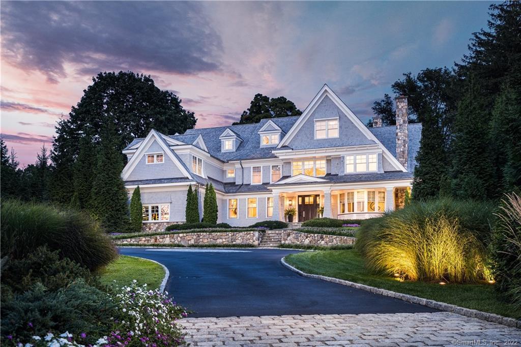 a front view of a house with a yard and lake view