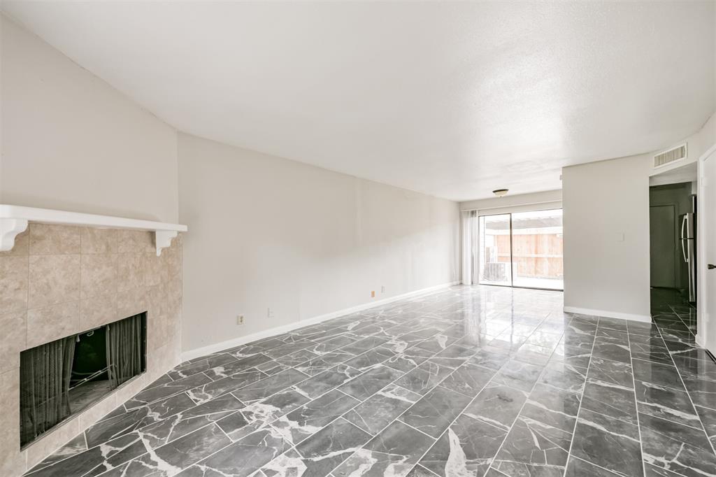 a view of empty room with wooden floor and fireplace