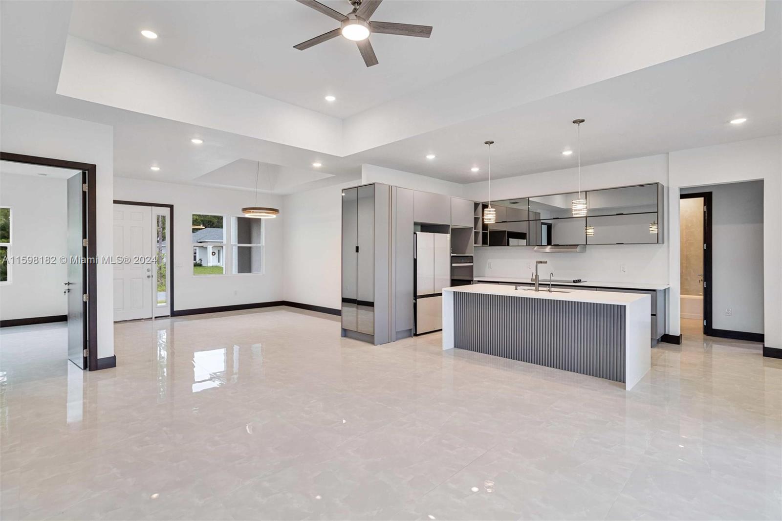 a large white kitchen with stainless steel appliances kitchen island a white counter space and a sink