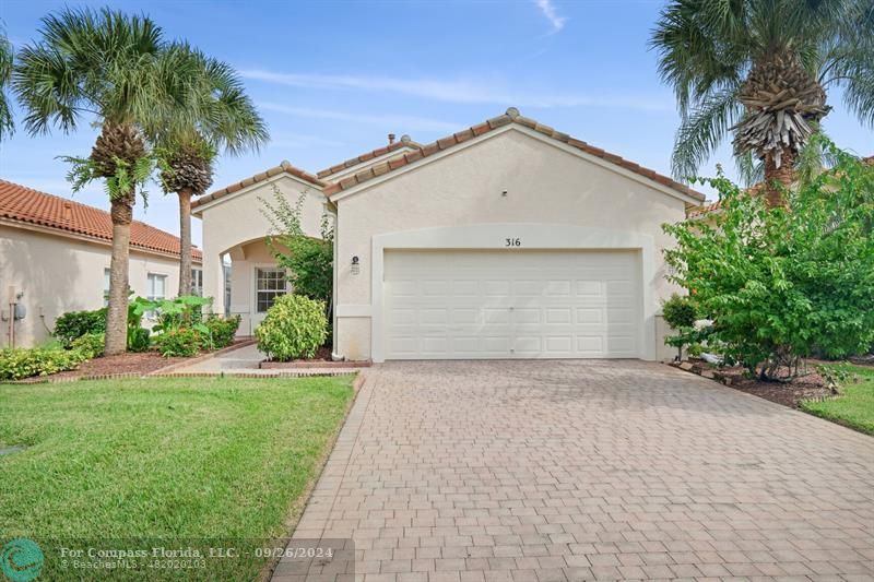 a view of a house with a yard and palm trees