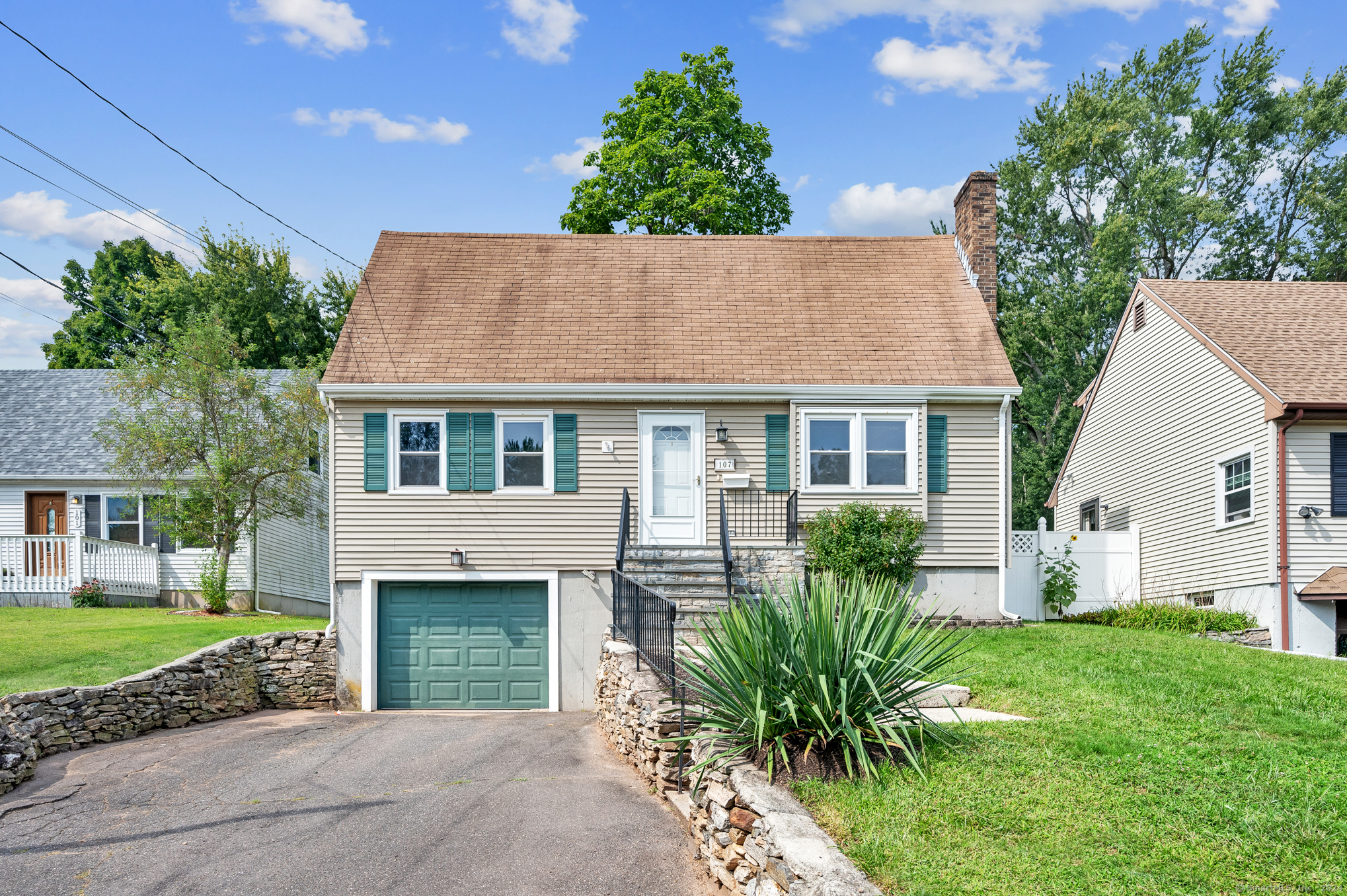 a view of a house with a yard and potted plants