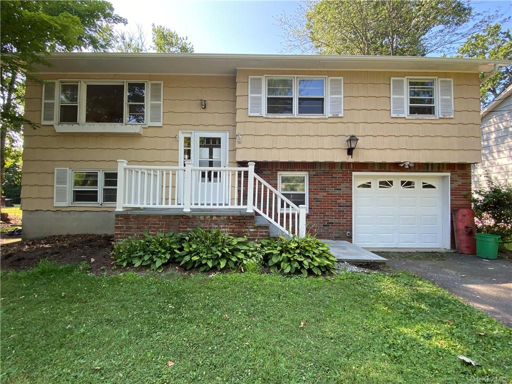 Split foyer home with a garage and a front lawn