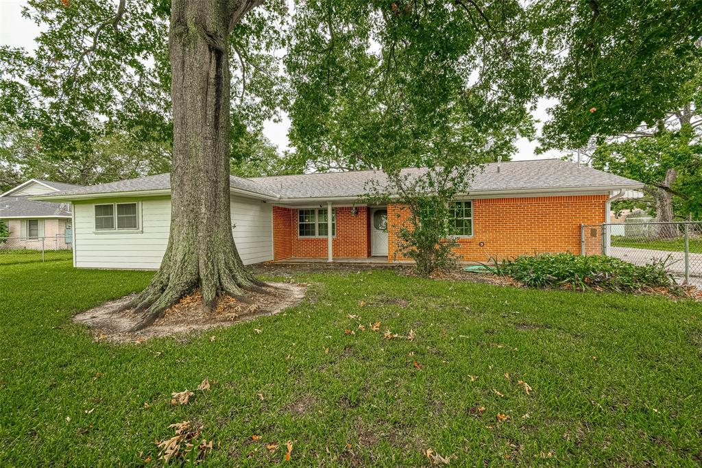 a view of a house with a backyard and a tree