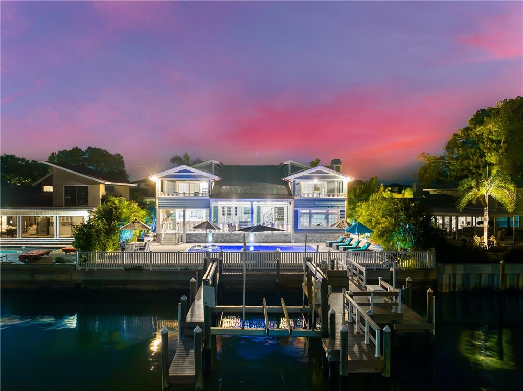 a front view of a house with swimming pool and outdoor seating