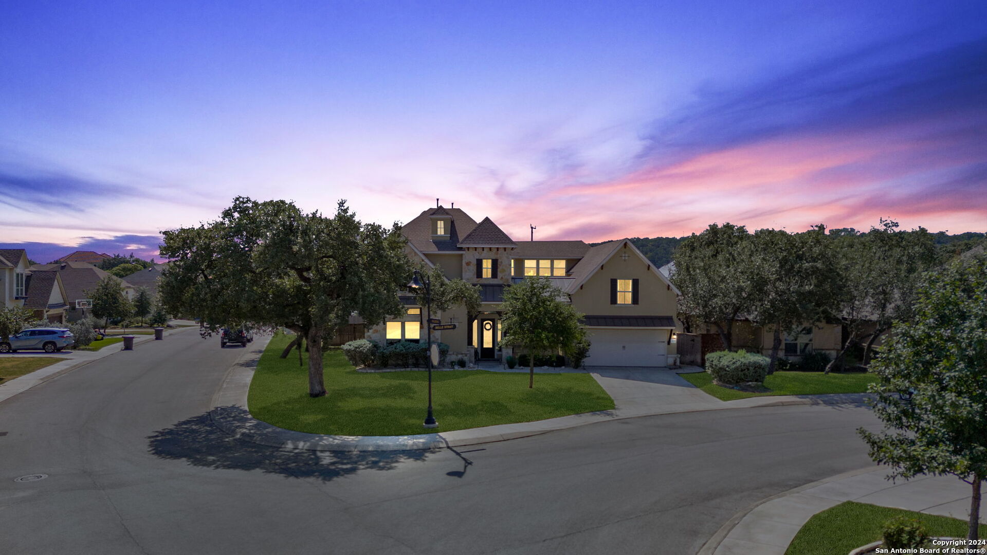 a front view of a house with a yard and trees