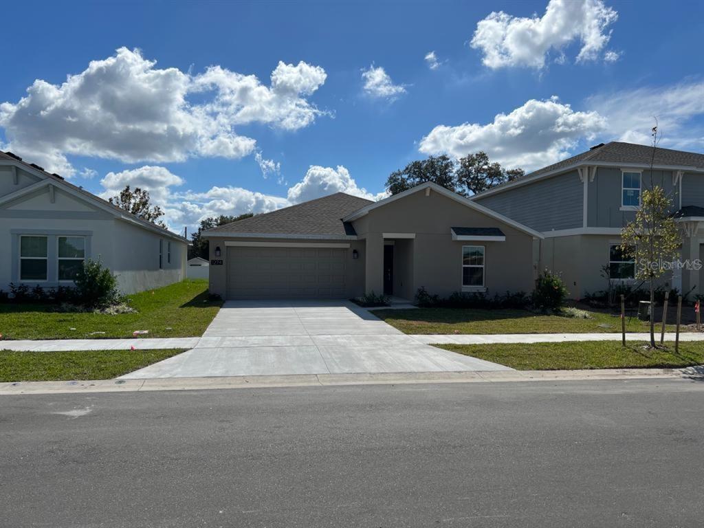 a front view of a house with a yard and a garage