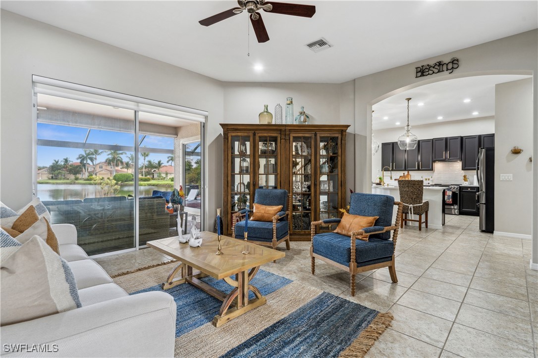 a living room with furniture a rug and a floor to ceiling window