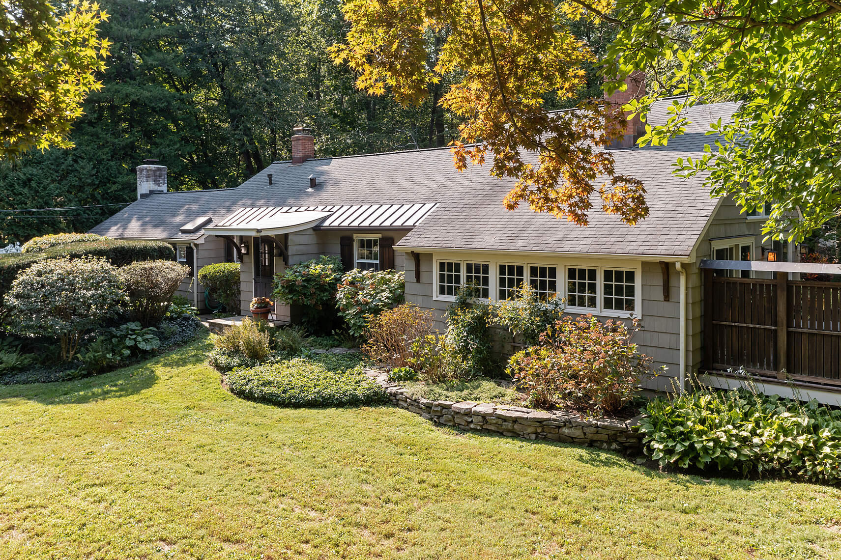 a front view of a house with a yard and potted plants