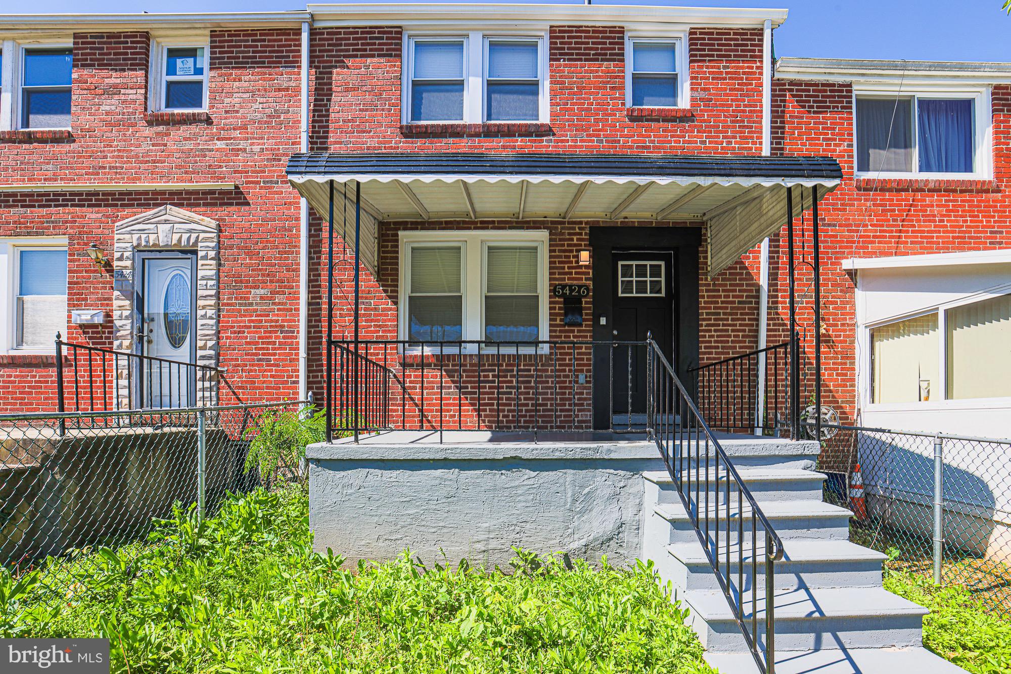 front view of a brick house with a yard