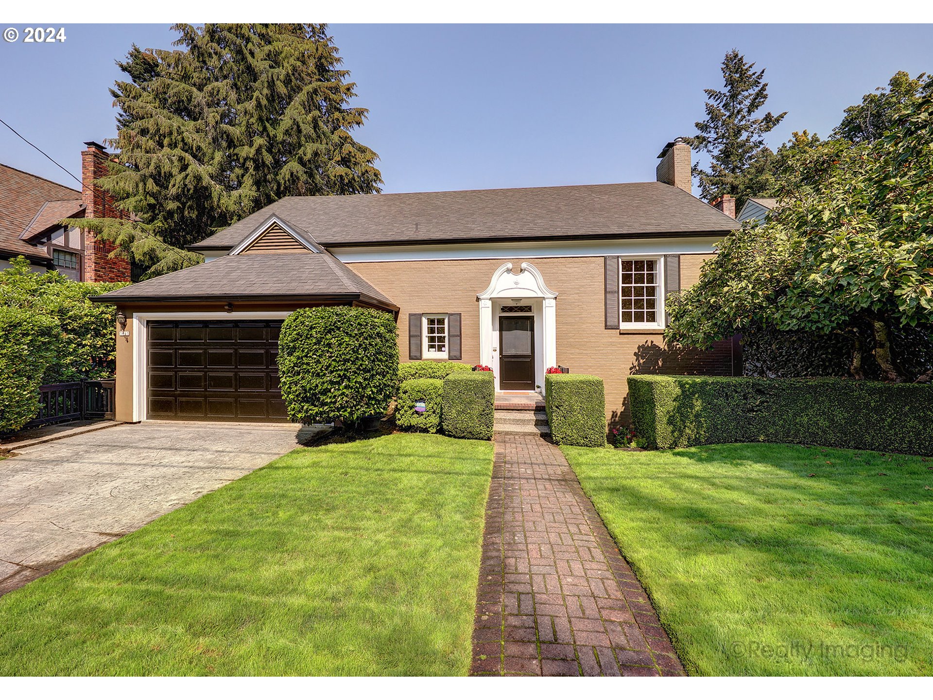 a front view of a house with yard and green space