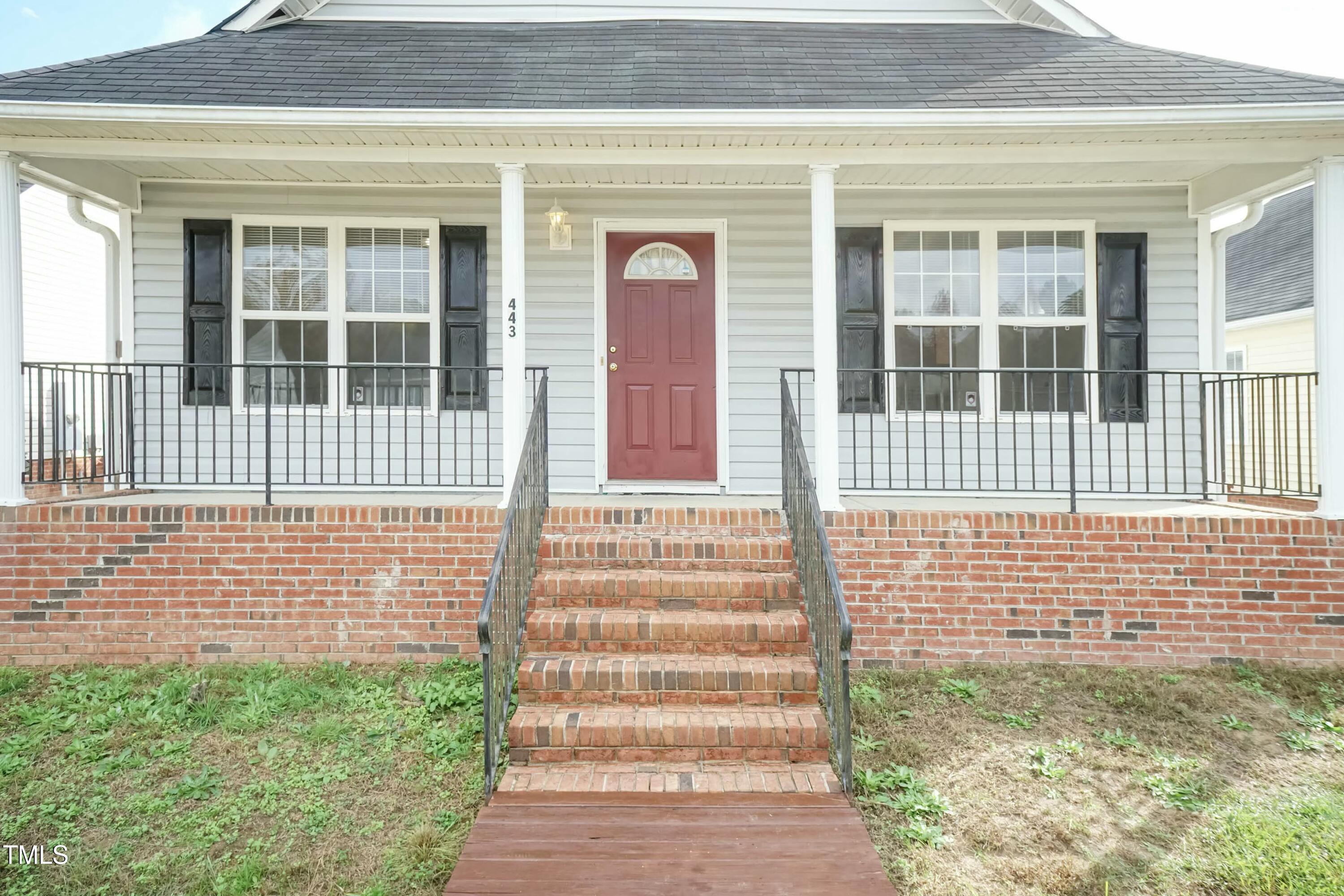 a front view of a house with a garden