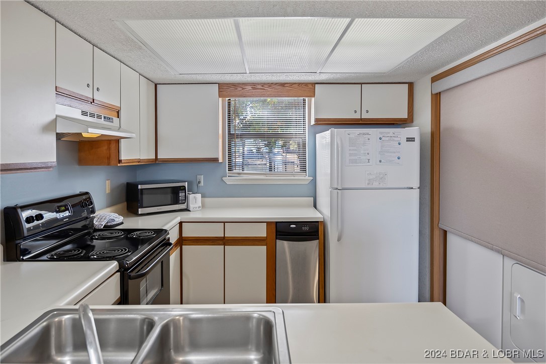 Full-sized washer & dryer in alcove in kitchen