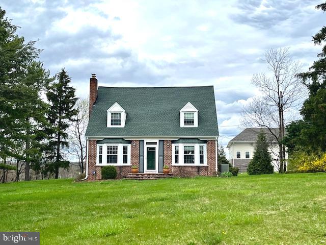 a view of a brick house with a big yard and large trees