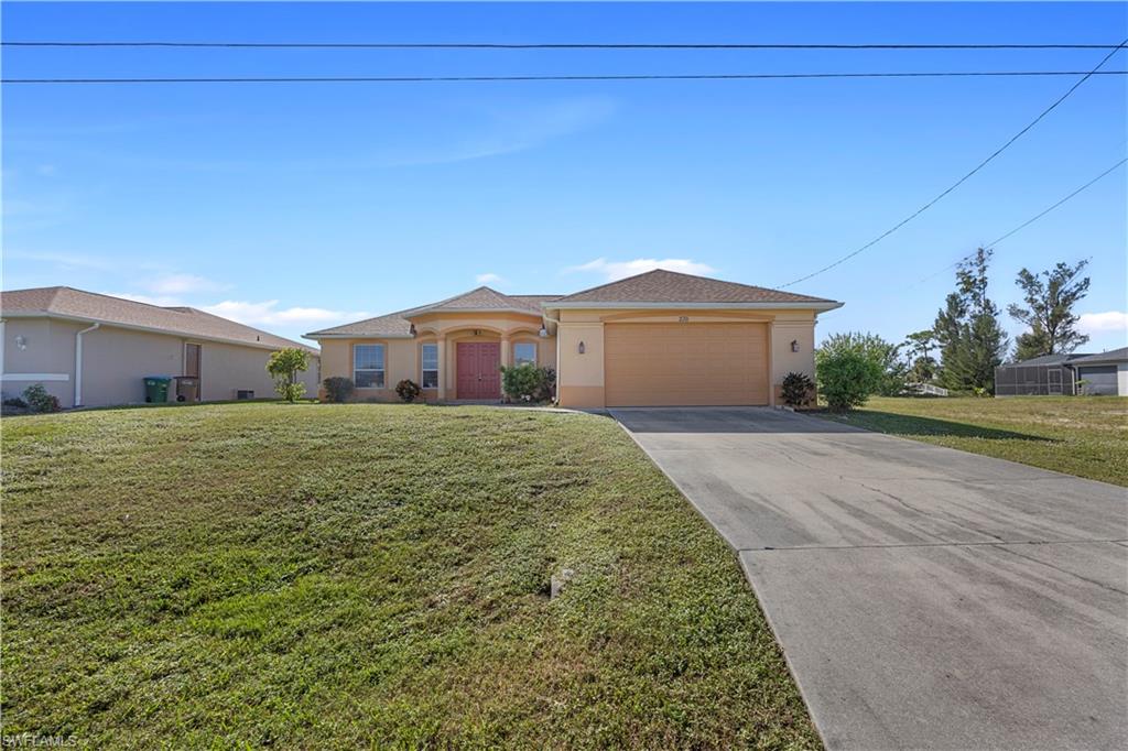 Single story home featuring a front yard and a garage