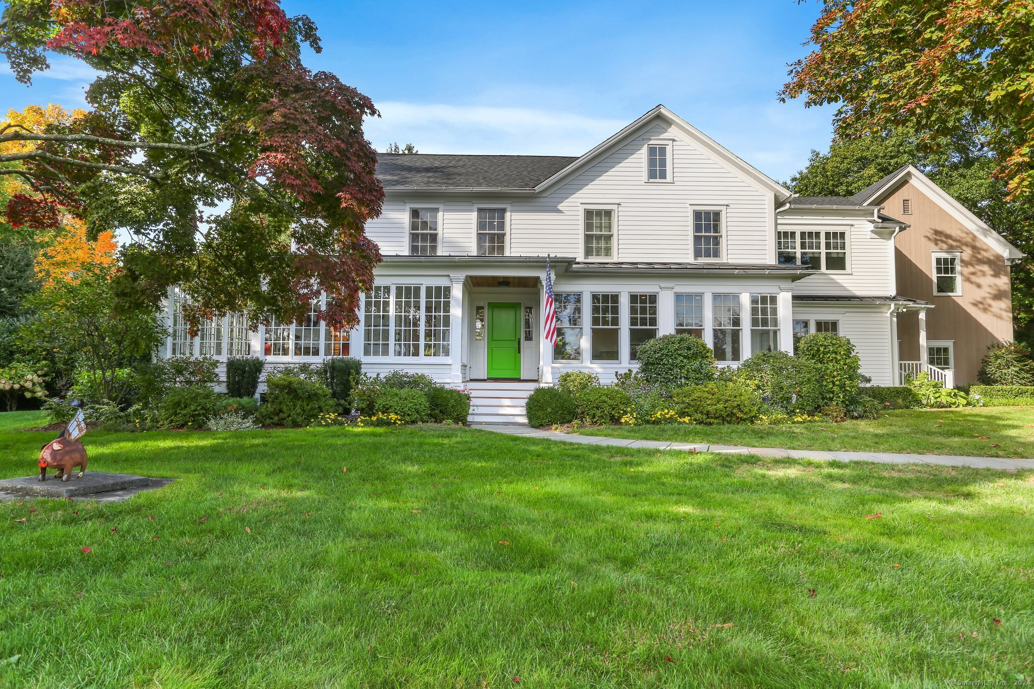 a front view of a house with a yard and trees