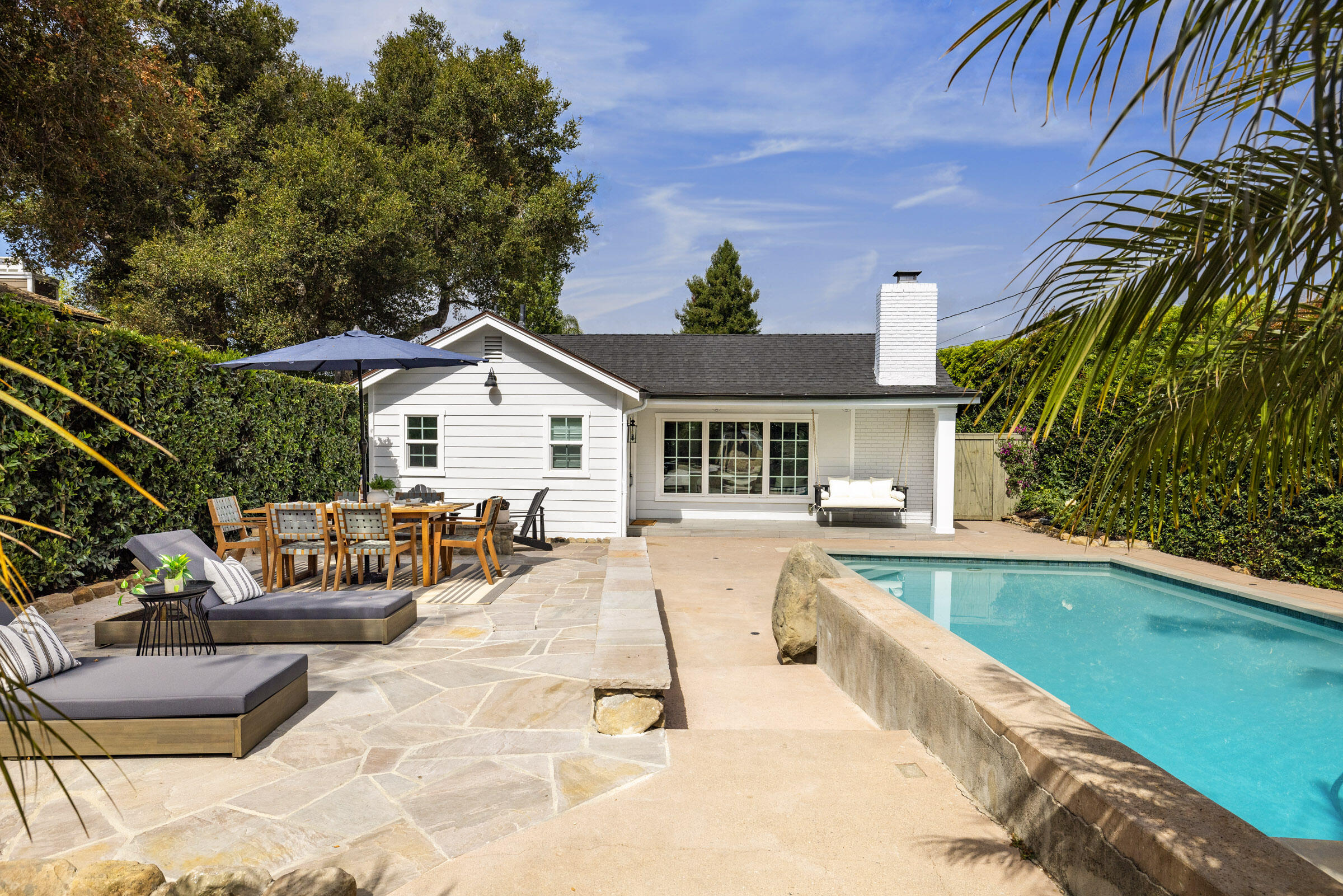 a view of a house with swimming pool and sitting area