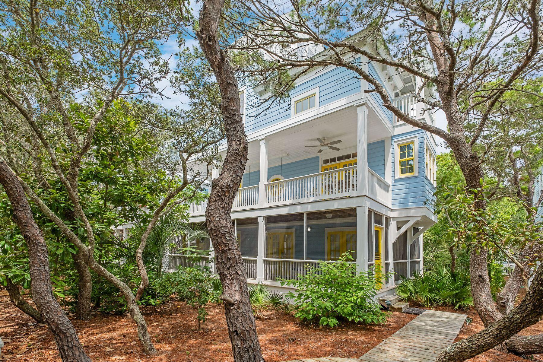 a front view of a house with plants and trees