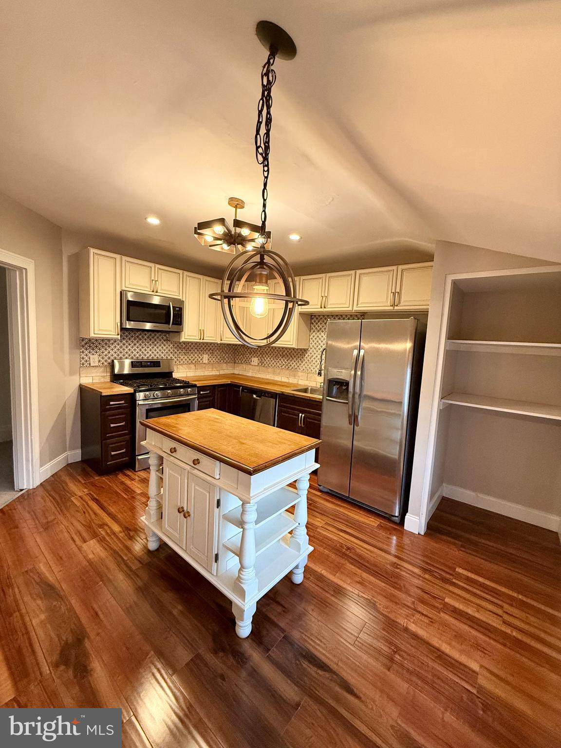 a kitchen with stainless steel appliances granite countertop a stove a sink and a wooden floors