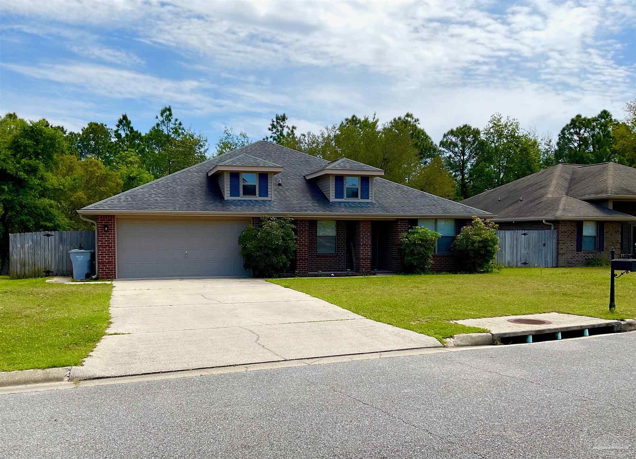 a front view of a house with a yard and trees