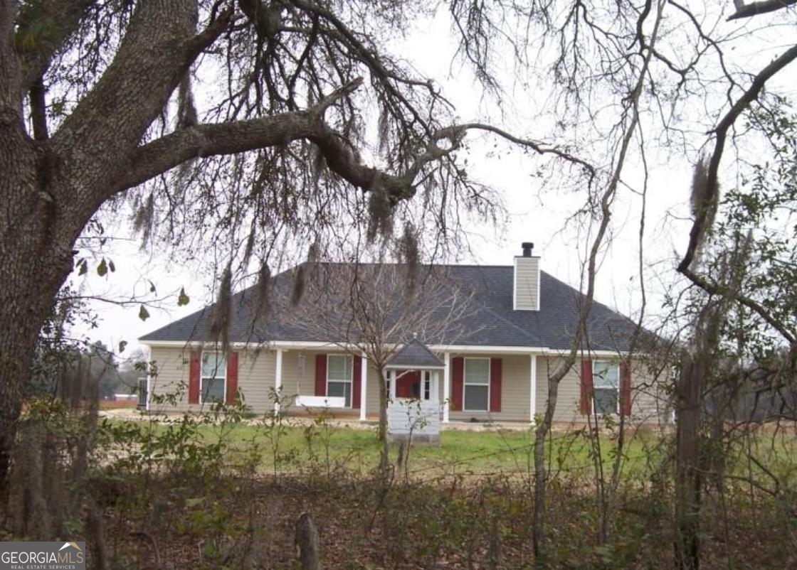 a brick house with trees in front of it