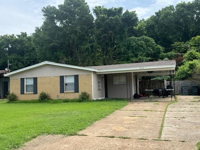 Ranch-style home with a carport and a front lawn