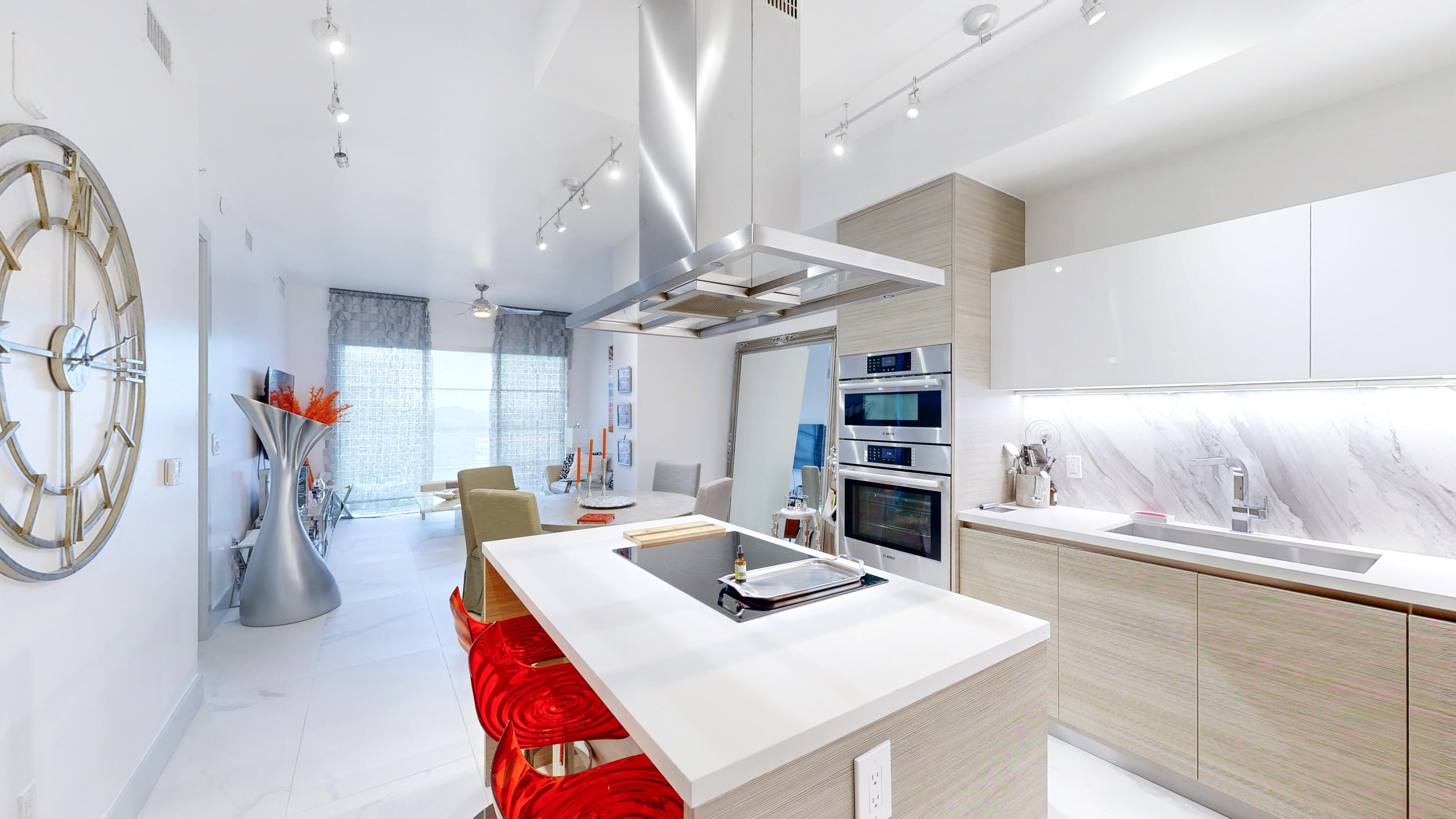 a living room with furniture a flat screen tv and kitchen view