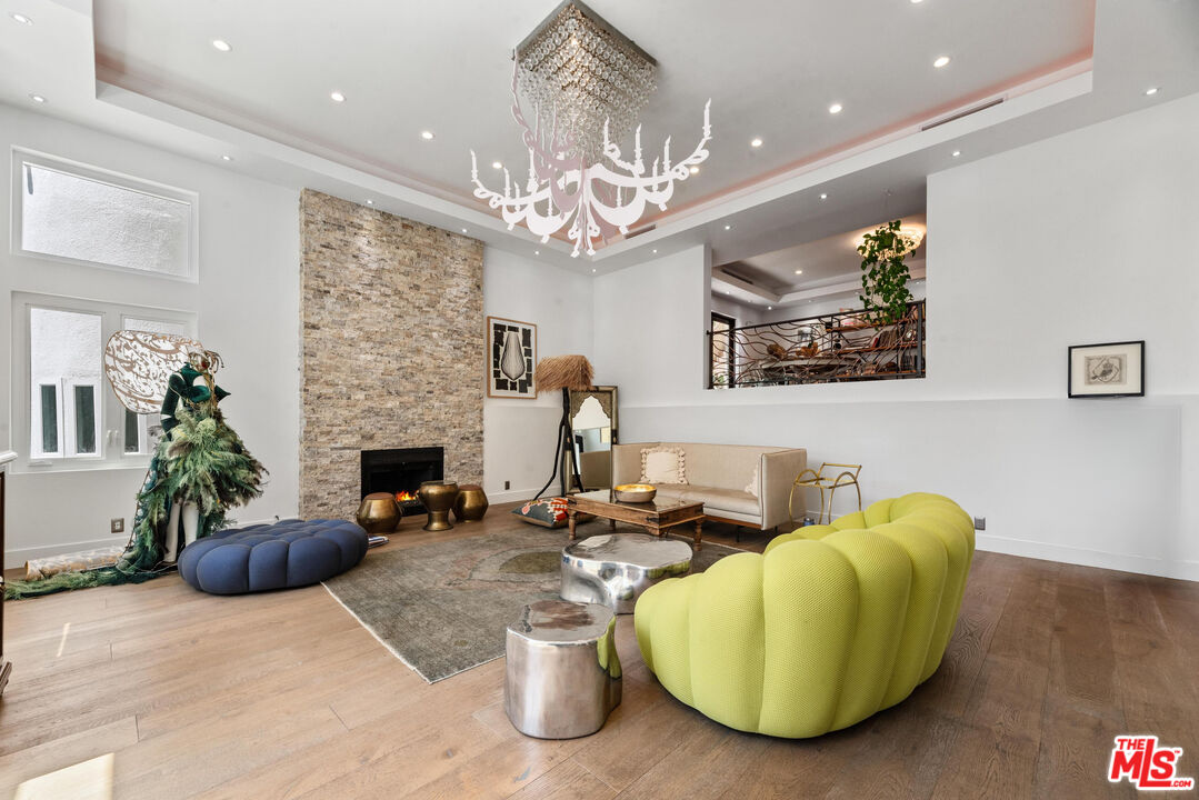 a living room with furniture a chandelier and a fireplace