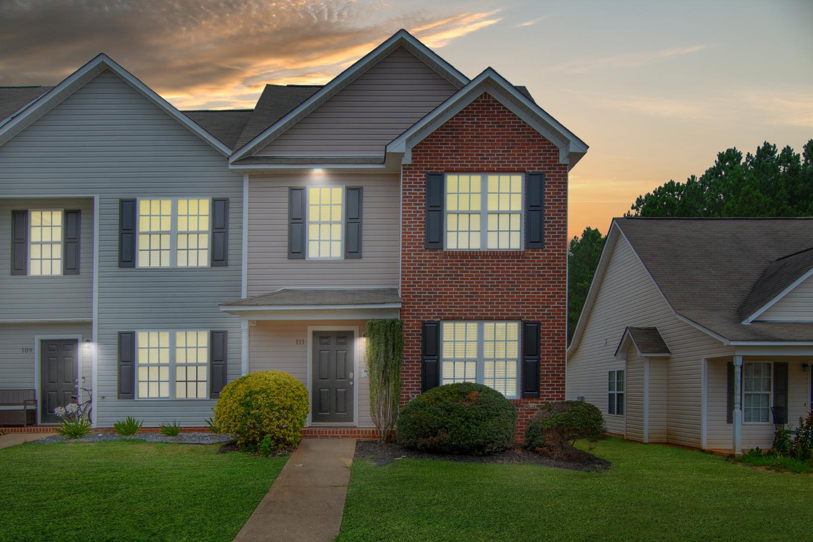 a front view of a house with a yard and outdoor seating