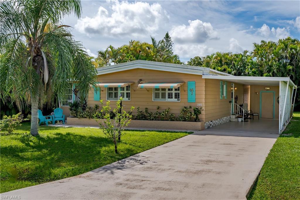 a front view of a house with a garden and yard