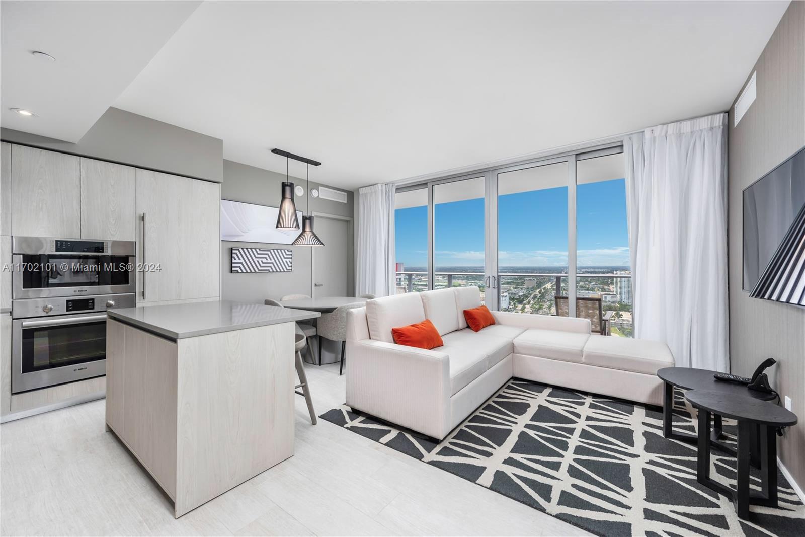 a living room with stainless steel appliances furniture and a window