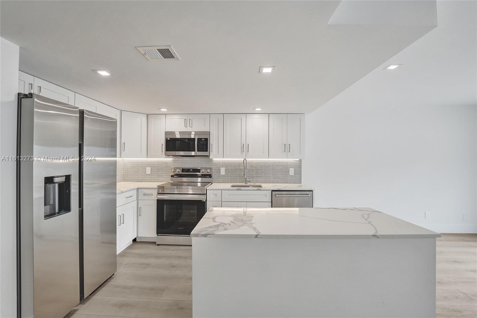 a kitchen with stainless steel appliances a refrigerator stove and microwave