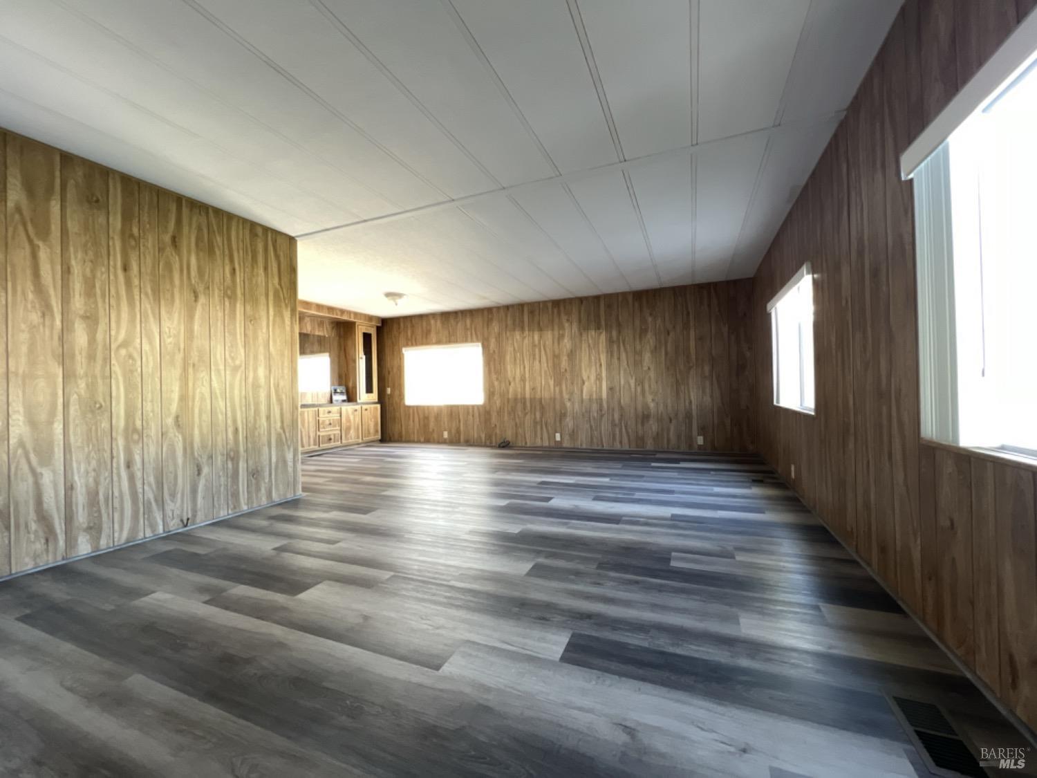 a view of a hallway with wooden floor and windows