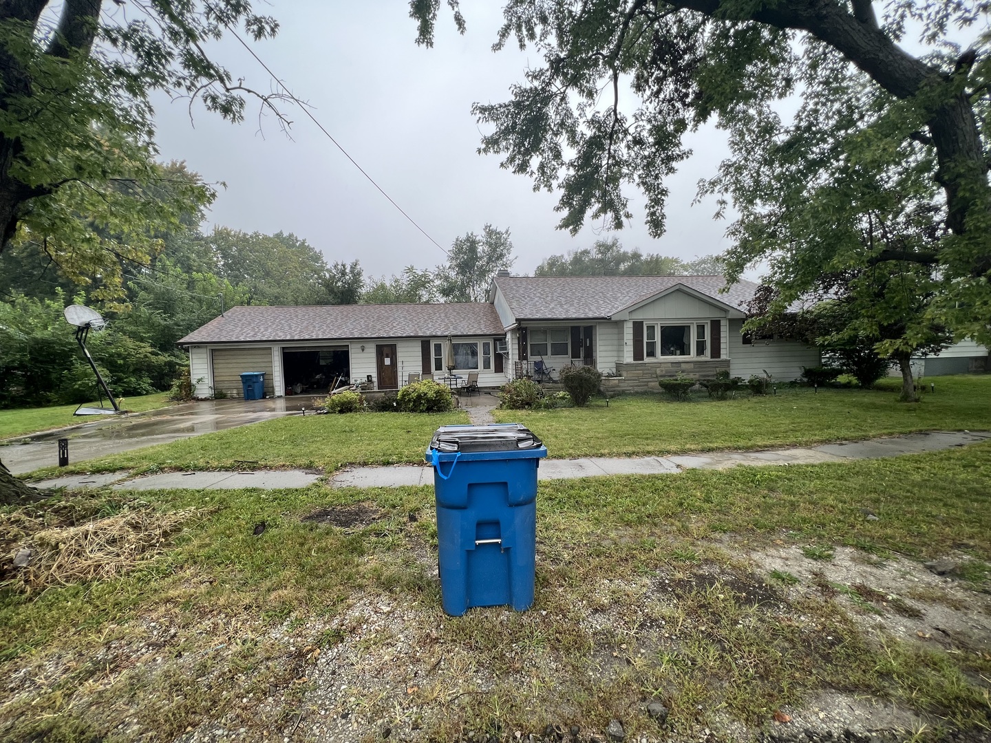 a front view of a house with a garden and trees