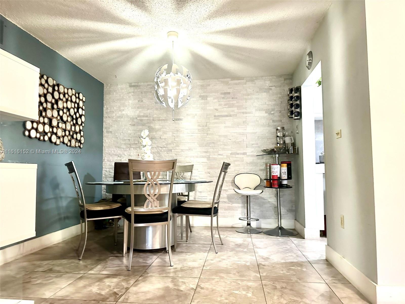 a dining room with chandelier furniture and a rug